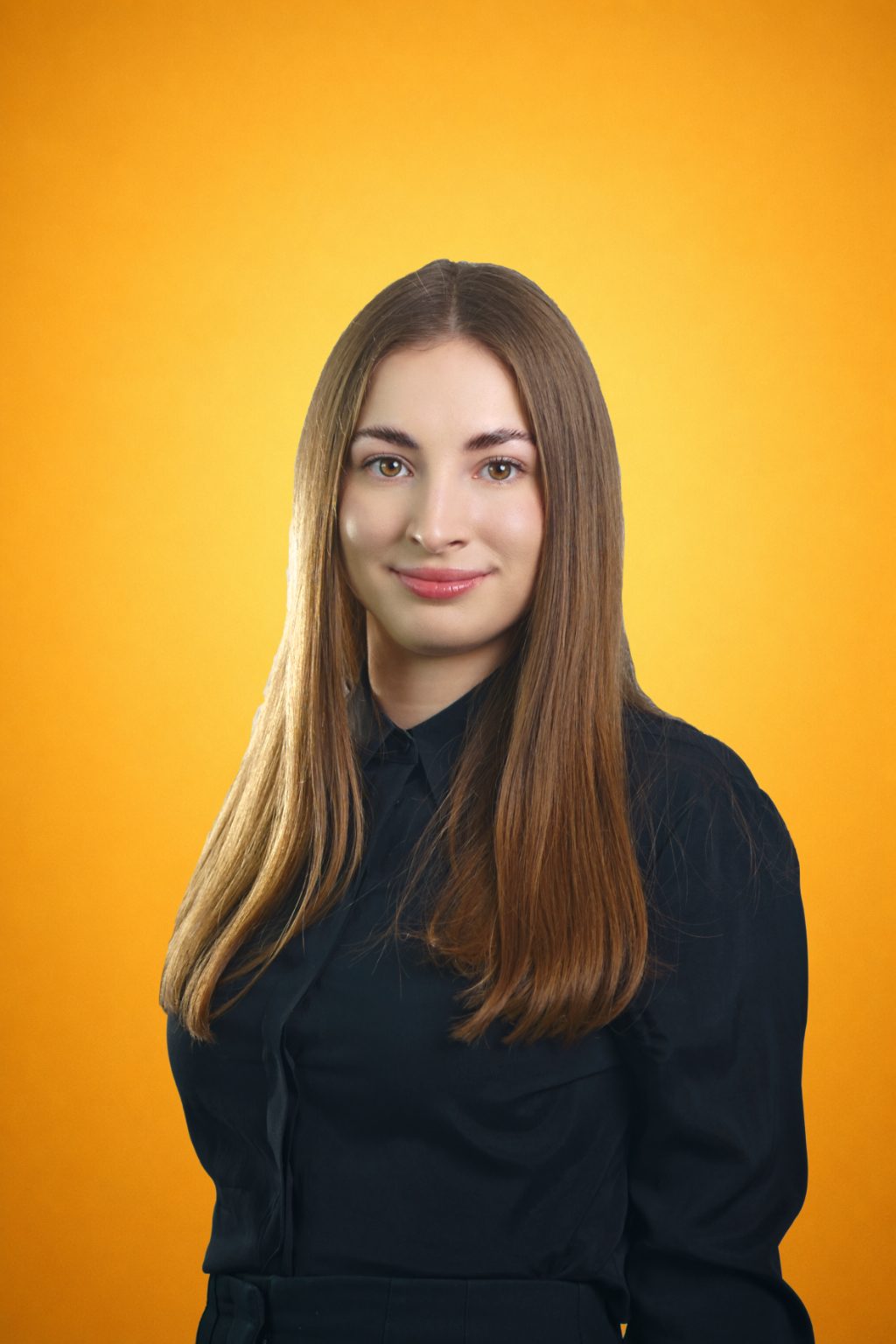 Portret biznesowy kobiety w czarnej koszuli na pomarańczowym tle
