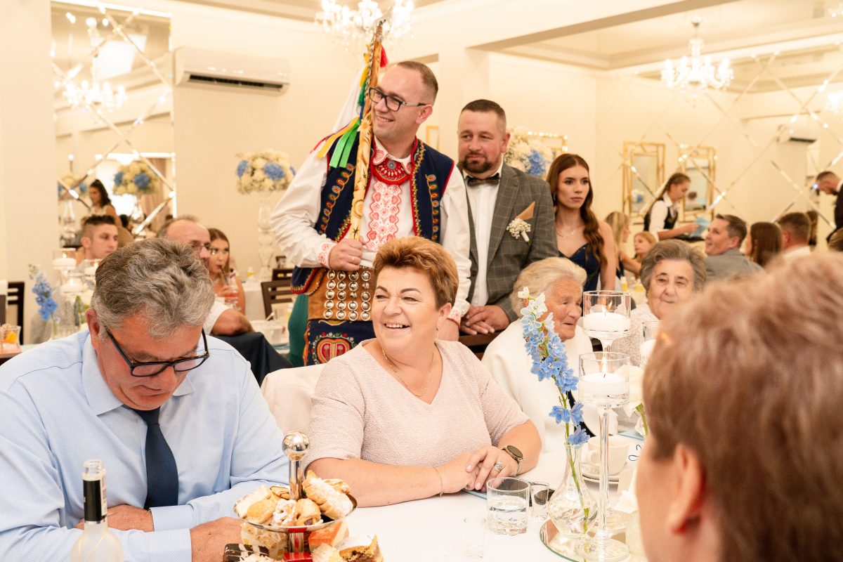 Kapela ludowa gra przy stole gości podczas przyjęcia weselnego